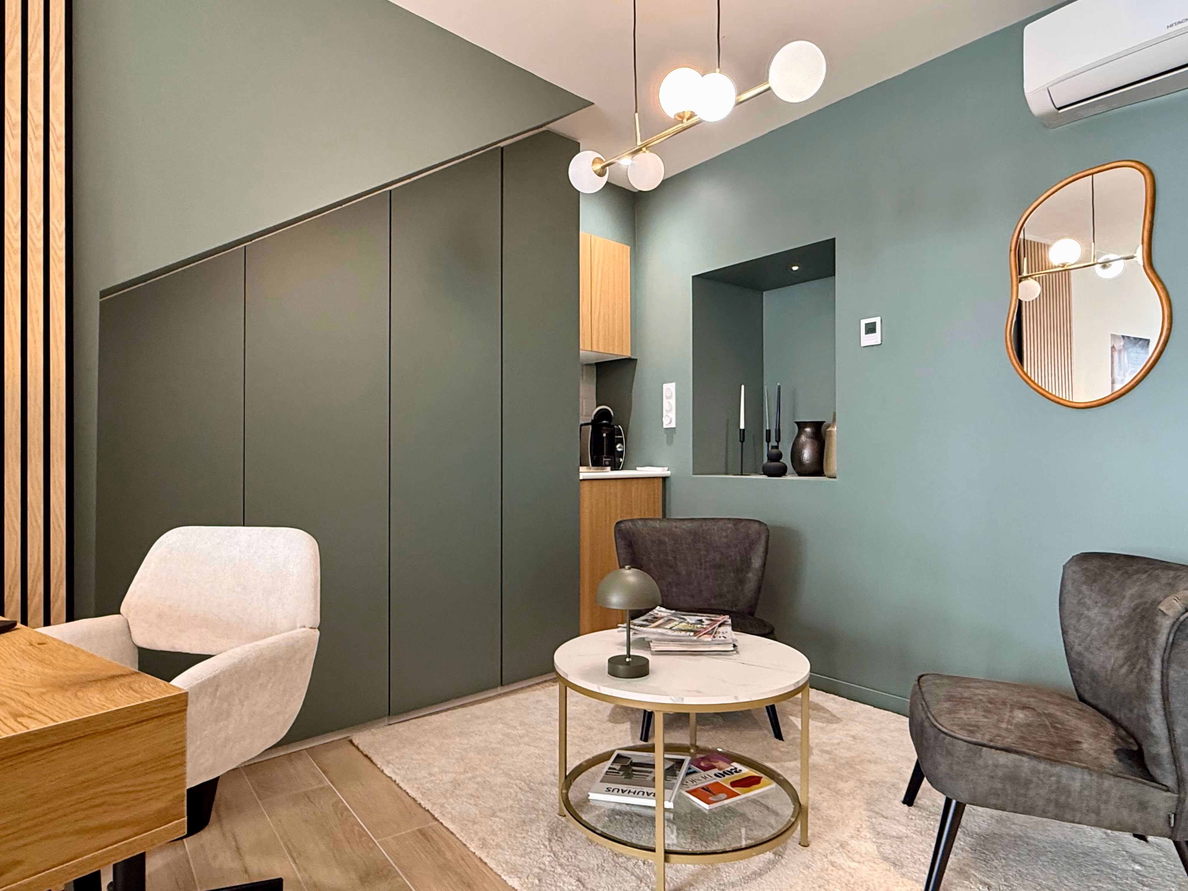 Coin salon de l'agence DÉCO.IMMO à Saint-Chély-d'Apcher, en Lozère, avec fauteuils et miroir décoratif